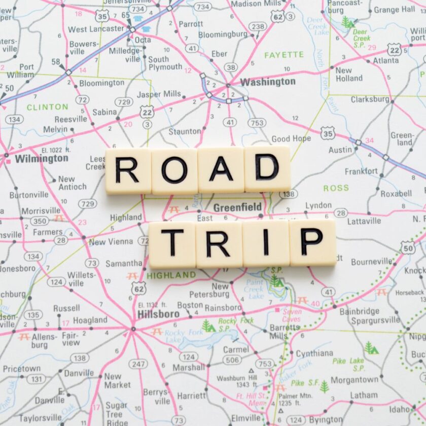 road trip written with scrabble tiles on a map