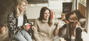 three friends sat on a sofa talking