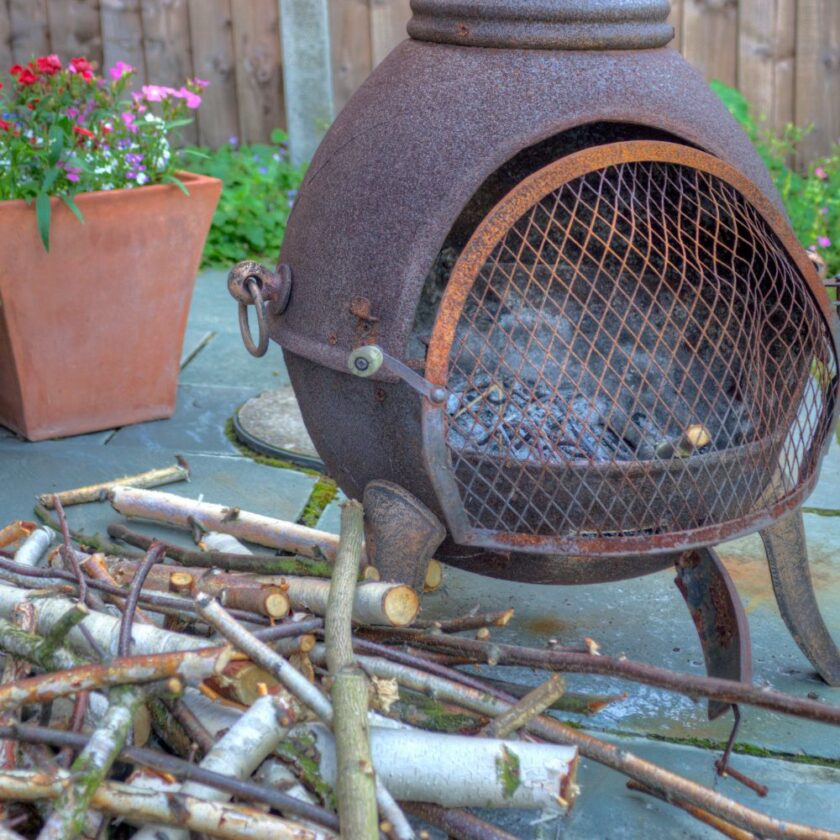 Chiminea and logs in a garden 