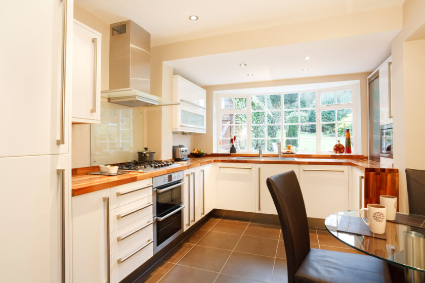 Contemporary designer kitchen and breakfast area with modern white units and stainless steel appliances
