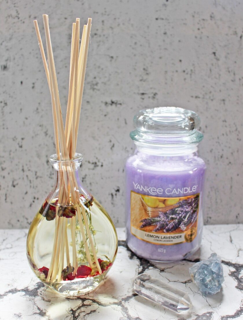 Yankee Candle in Lemon Lavender stood beside a reed diffuser with dried rose buds in