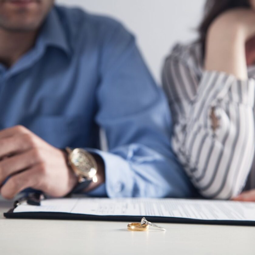 couple with wedding rings on table in front of them
