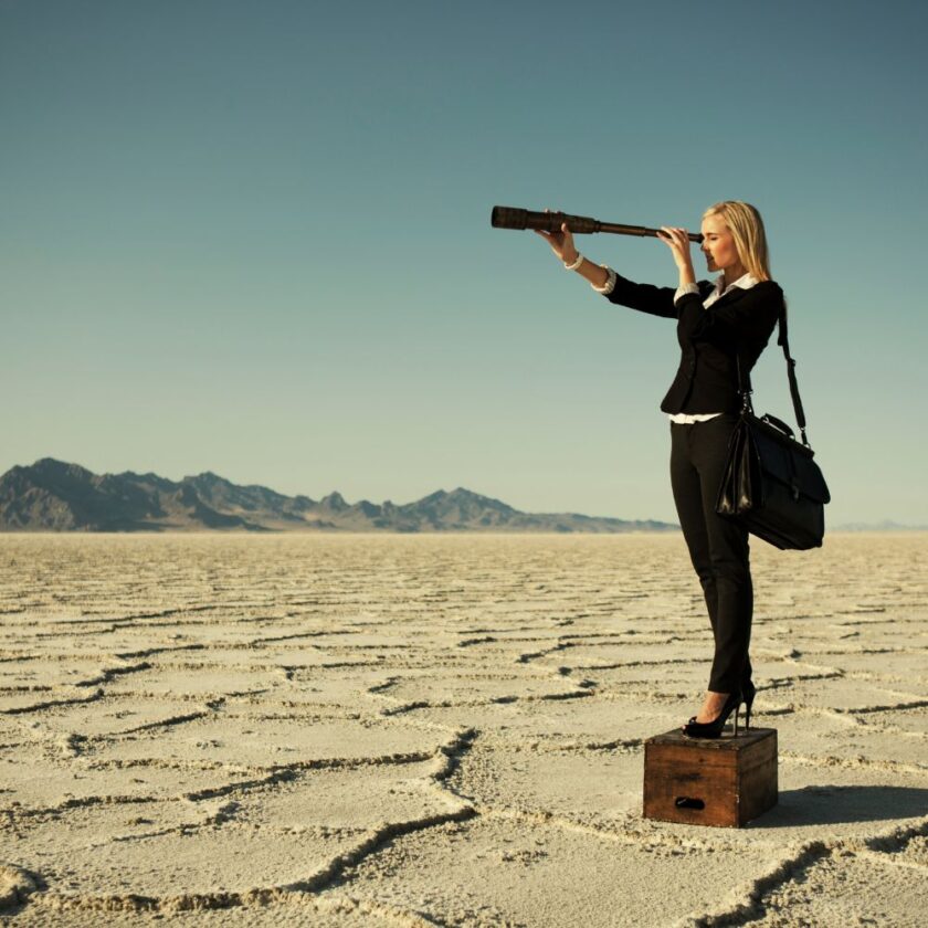 person looking through a telescope in the desert