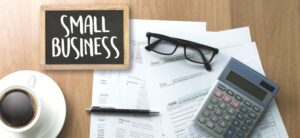 small business written on a slate with coffee glasses pen and paper