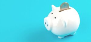 small white piggy bank with a coin in the slot