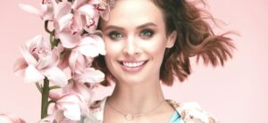 spring fashion woman standing by spring flowers