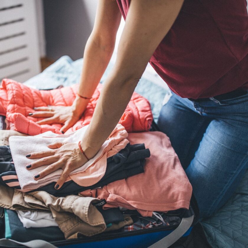 woman packing clothing into a suitcase
