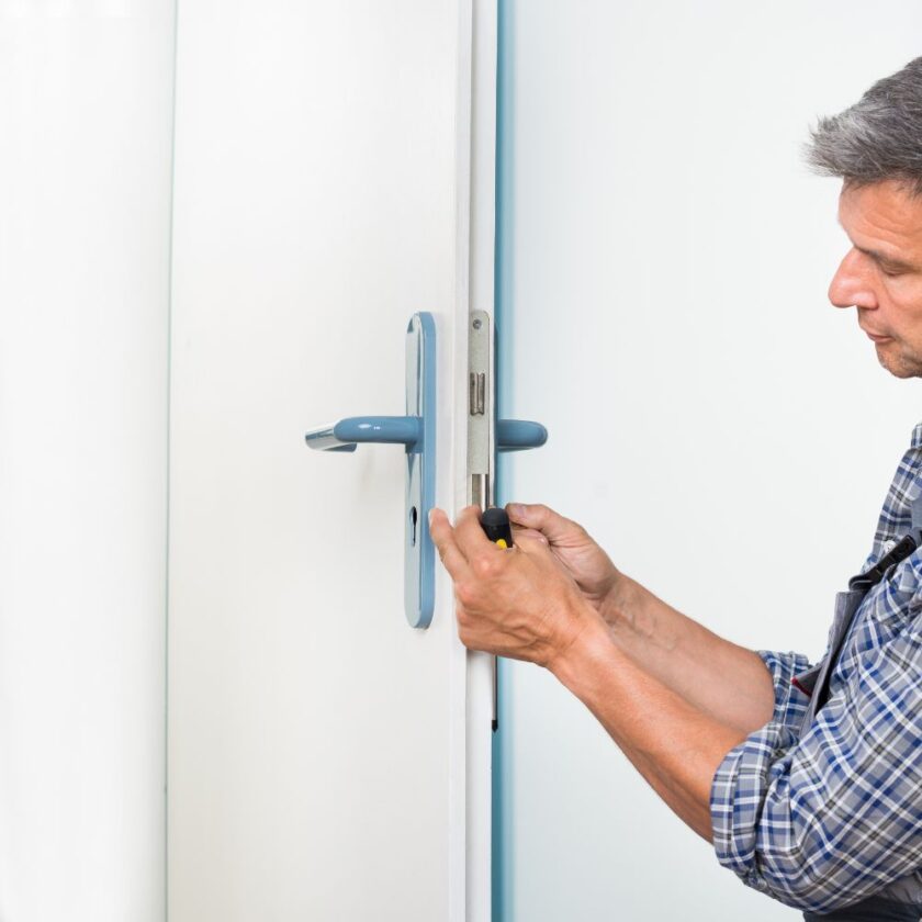 carpenter fixing a lock on a door
