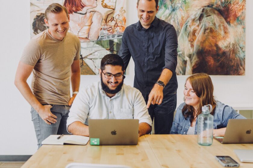 Group of collegues gathered around a computer