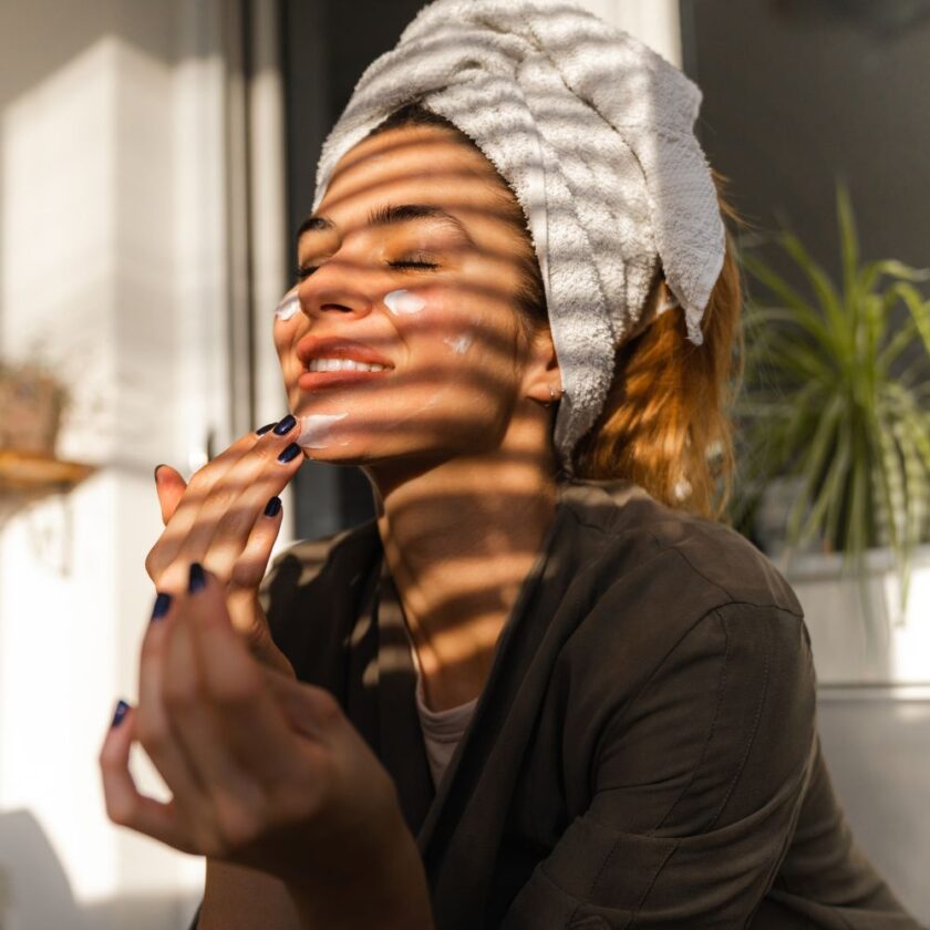 woman doing some self care at home by putting on facecream