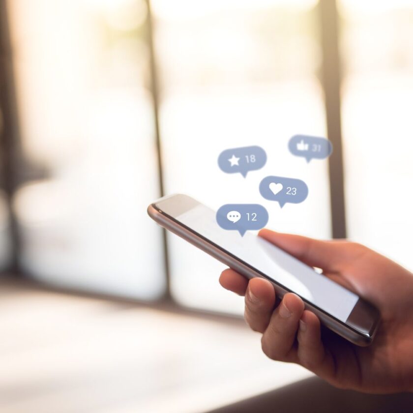 hand using a smart phone to look at social media