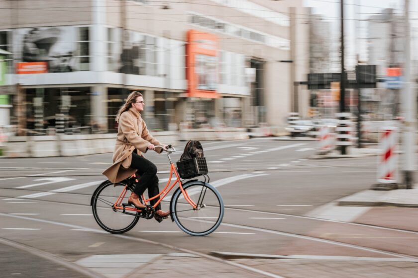 woman cycling on a bike through a city