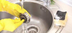 person cleaning a kitchen sink