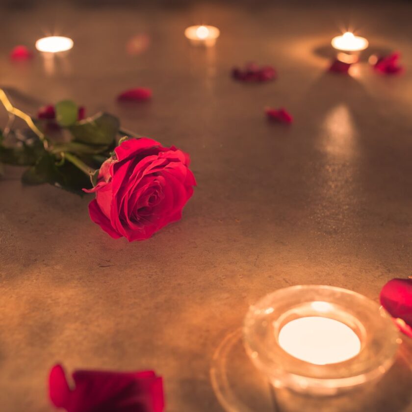 rose in water with candles around it