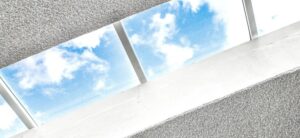 skylight in a roof looking out onto a blue sky