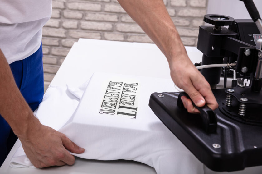 Man printing on t shirt in workshop