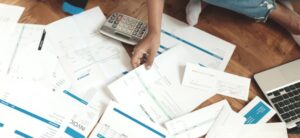 person sat with a load of invoices around them