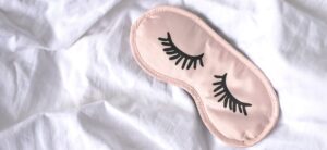 sleep mask resting on a white sheet