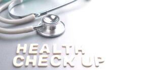 the words health check up below a stethoscope