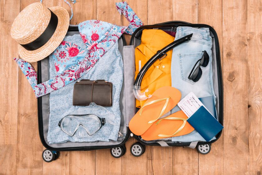 Suitcase packed with womens clothing ready for a holiday