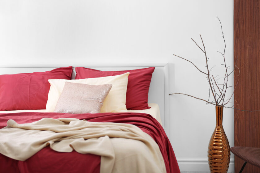 Comfortable bed with burgundy bedding in modern interior design