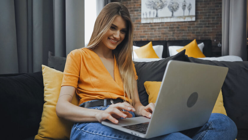 Woman looking happy working on her laptop at home