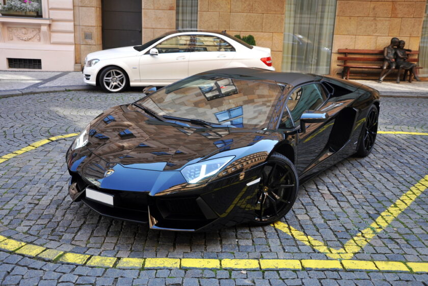 black new lamborghini aventador near luxury hotel
