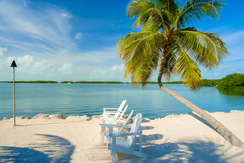 Beautiful Florida Keys along the shoreline with lounge chairs and gulf view.