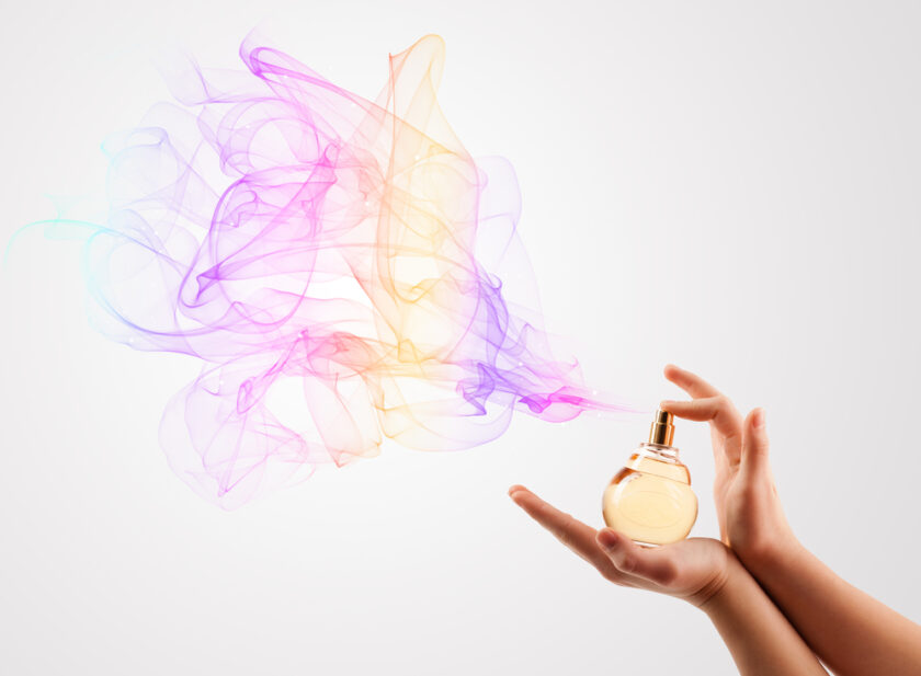close up of woman hands spraying perfume