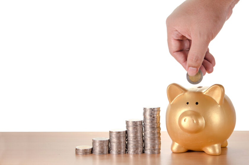 man hand with coins plan to saving money with gold piggy bank isolated on white background