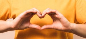 woman holiding her hands in a heart shape