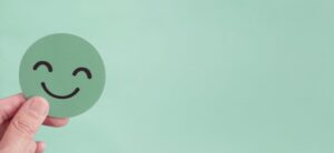 person holding a green smiling face