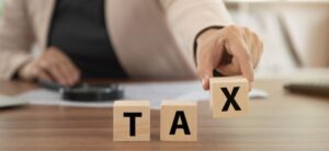 woman spelling out tax with wooden blocks