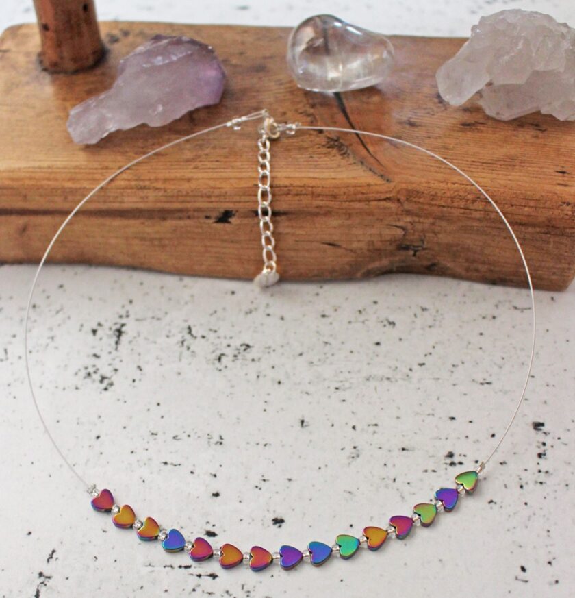 Carrie Elspeth Rainbow Haematite Hearts Necklace with gem stones in background