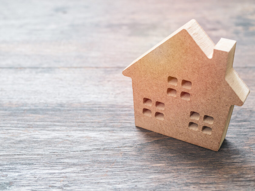 Wooden house on old wooden background with copy space.
