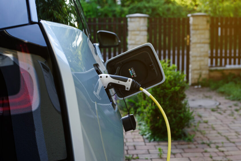 Power supply for electric car charging at home. Electric car charging station. Power supply joined to modern electric car being charged.