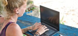 digital nomad woman working on the beach