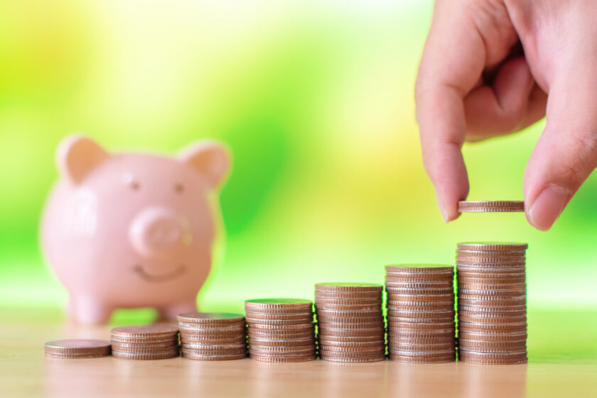 Hand of male or female putting coins money stack step growing growth saving money with piggy bank. Concept finance business investment