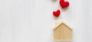 small wooden house with red kitted hearts