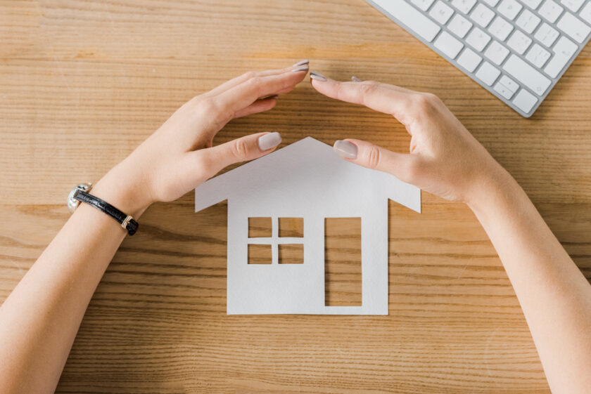 Hands over a paper house