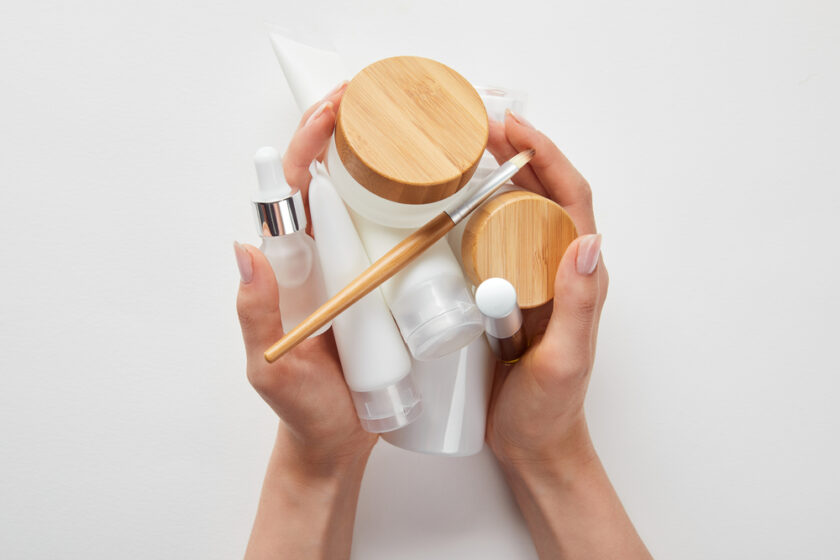 Woman holding a range of skincare tubs and bottles