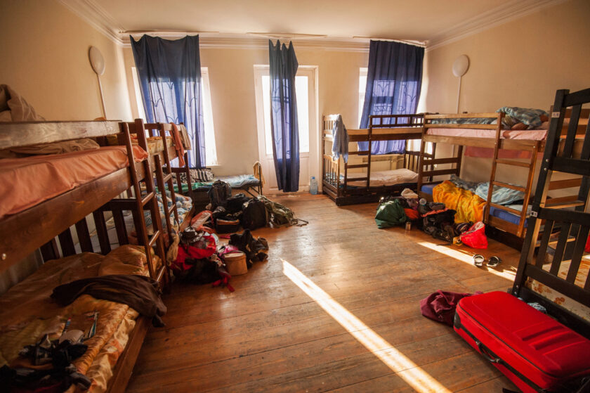 Hostel room with backpacks, clothing and luggage around.