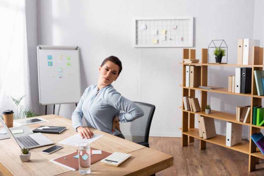 Person sat a desk suffering from back pain