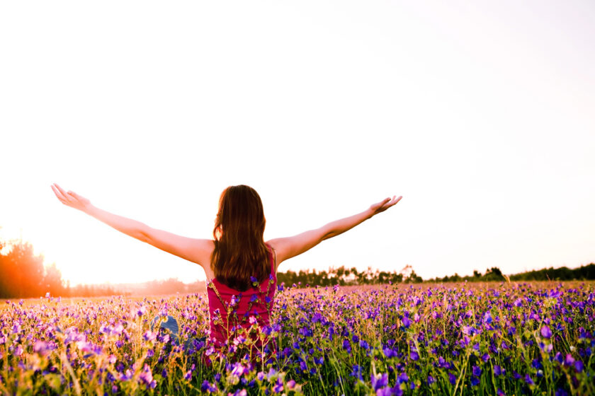 Woman in a medow with her arms out