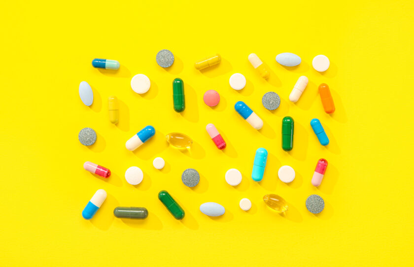Different pills on yellow background