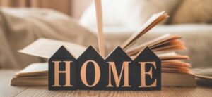 home sign with an open book behind it