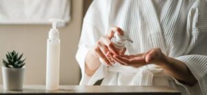 woman applying skincare in a bathroom