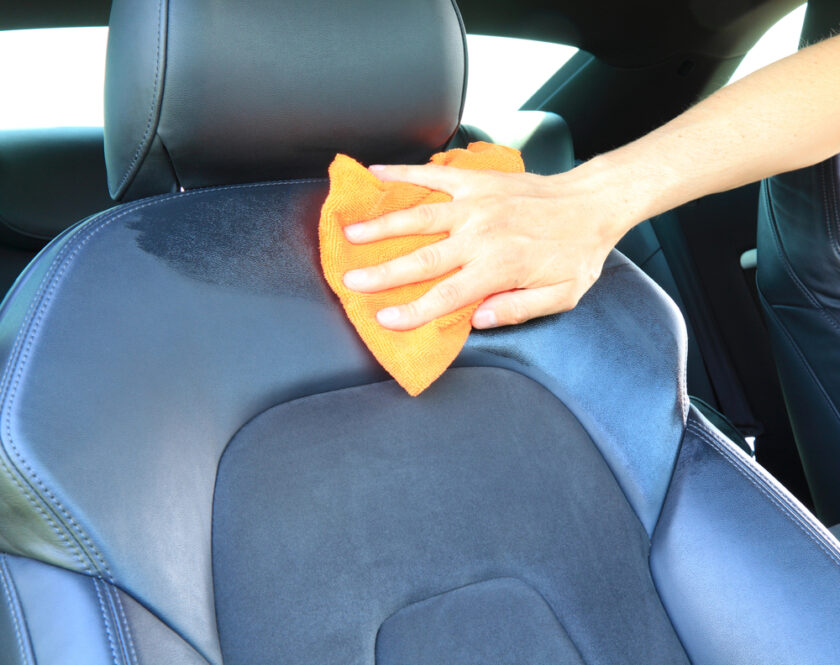man cleaning the inside of a car 