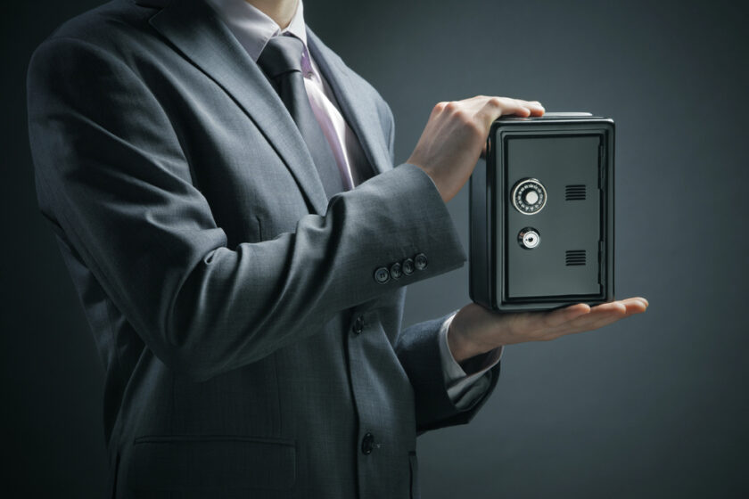 business man holding a safe with his money in