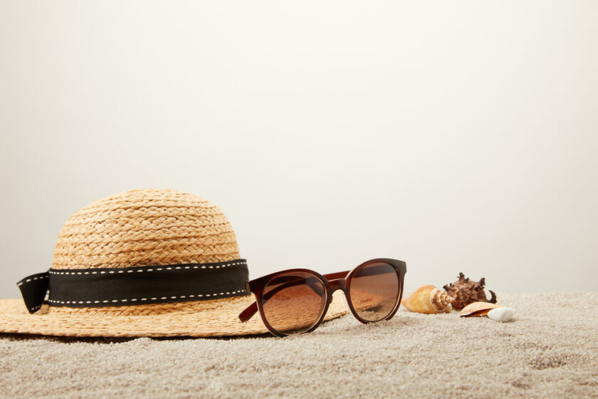 Hat and sunglasses on sand